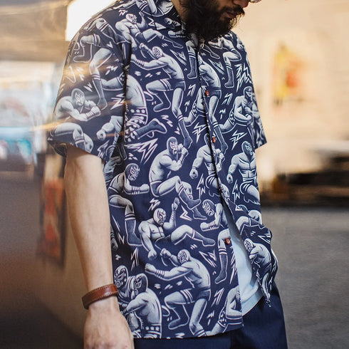 Person wearing a navy blue shirt with white graphic designs of people in various poses.